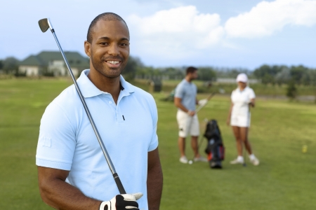 Closeup portrait of handsome young black golfer with golf club, smiling, looking at camera.の写真素材