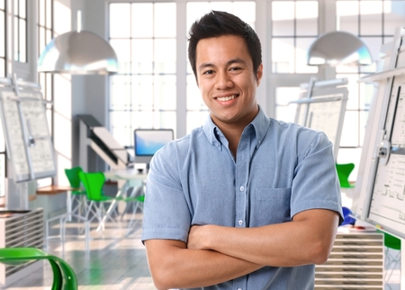 Young asian architect standing and smiling for camera at design studio.の写真素材