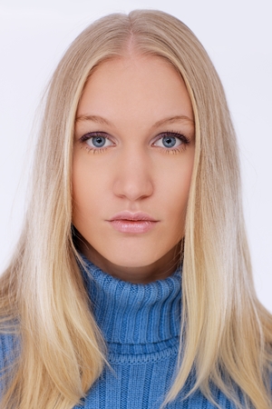 Closeup portrait of attractive young blonde woman with blue eyes, looking at camera.の写真素材