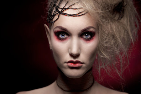 Studio portrait of woman in halloween makeup, black background.