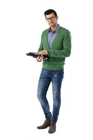 Casual young man standing over white background using tabletの写真素材