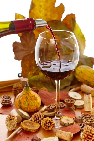 Glass of wine at vintage time among autumn decoration.の写真素材