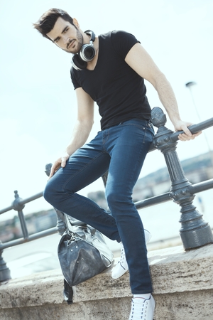 Casual man sitting at riverside, outdoors.の写真素材