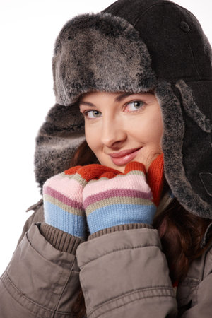 Young woman in warm outdoor clothing, looking at camera, smiling, white background.