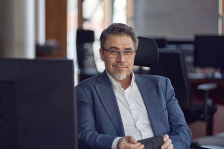 Business portrait - Businessman sitting at desk in office.の写真素材