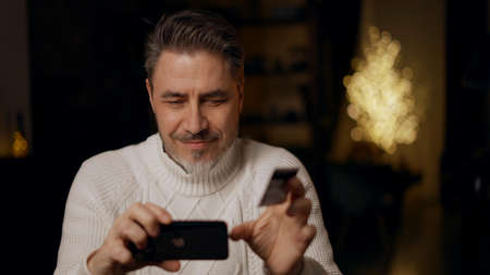 Man shopping paying online with credit card and phoneの写真素材