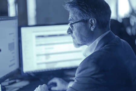 Businessman working with computer at office desk, thinkingの写真素材