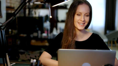 Happy woman working with laptop in home officeの写真素材