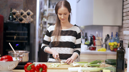 Woman cooking in kitchen at homeの写真素材