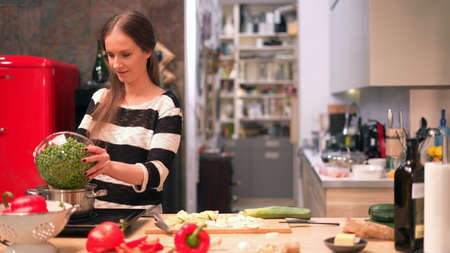 Woman cooking in kitchen at homeの写真素材