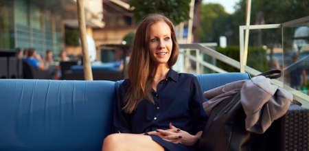 Elegant woman sitting outdoor in restaurantの写真素材
