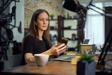 Businesswoman with laptop managing small business in home officeの写真素材