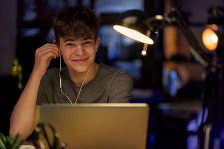Teenage student learning at home with books and laptop computerの写真素材