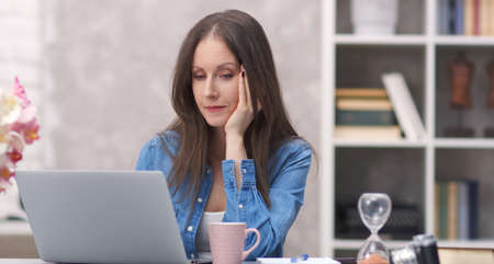Woman working with laptop at home officeの写真素材