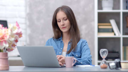 Woman working with laptop at home officeの写真素材