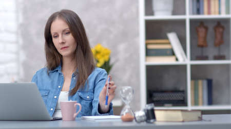 Woman working with laptop at home officeの写真素材