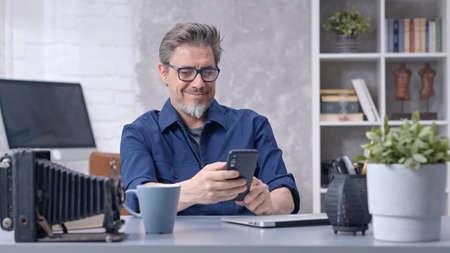 Man working with laptop and smart phone at home officeの写真素材