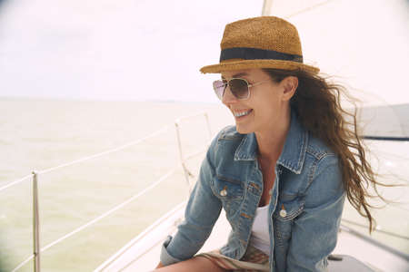 Woman relaxing on sailing boat enjoying summer vacationの写真素材