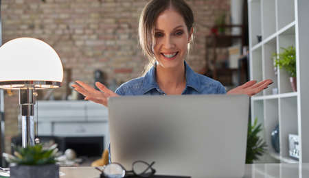 Happy woman on video chat with laptop at home.の写真素材