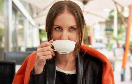 Woman drinking tea on cafe terraceの写真素材