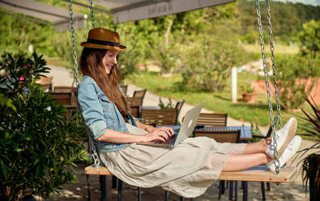 Woman working online with laptop in gardenの写真素材
