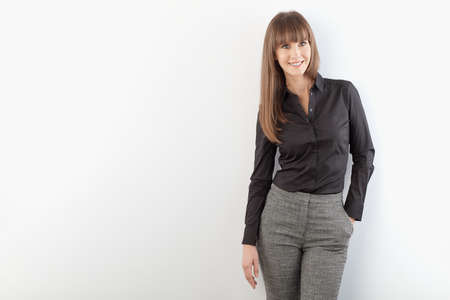 Happy young businesswoman standing at wallの写真素材