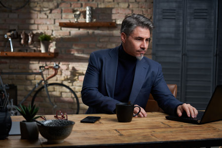 Businessman working with laptop computer at desk in officeの写真素材