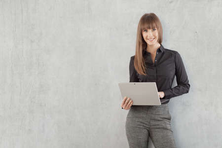 Happy young businesswoman with laptop computerの写真素材