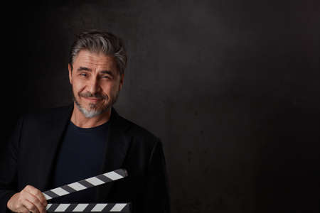 Happy man holding clapper boardの写真素材