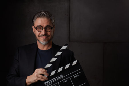 Happy man holding clapper board