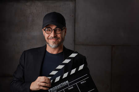 Happy man holding clapper boardの写真素材