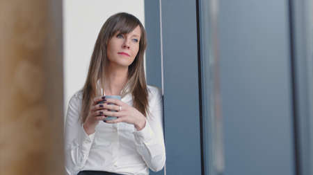 Businesswoman in office drinking coffeeの写真素材