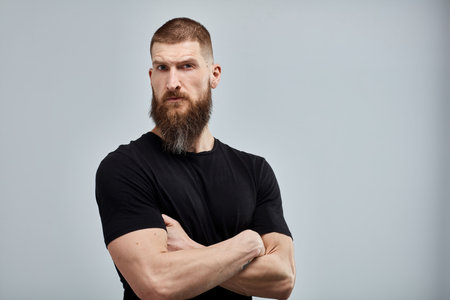 Bearded man standing against white wallの写真素材