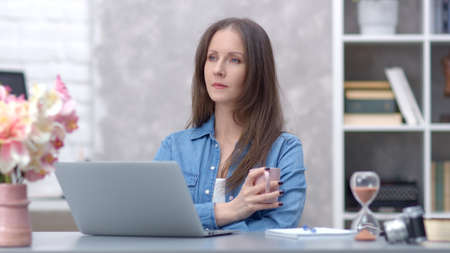Woman working with laptop at home officeの写真素材