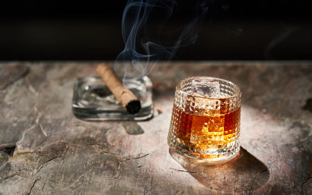 Glass of whiskey and smoking cigarの写真素材