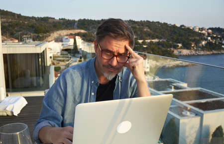 Man working with laptop at home office on terraceの写真素材