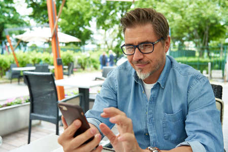 Portrait of happy smiling mid adult man with phoneの写真素材