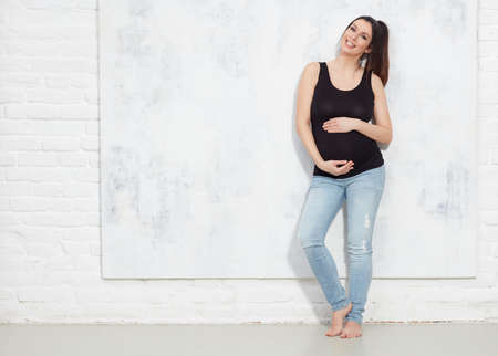 Happy pregnant woman in jeansの写真素材