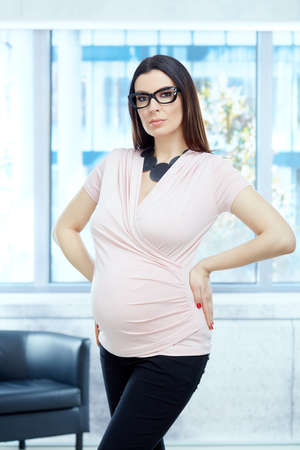 Serious pregnant woman working in modern officeの写真素材