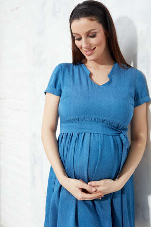 Happy pregnant woman in blue summer dressの写真素材