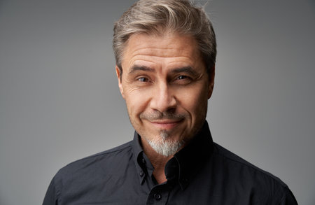 Business portrait - businessman smiling. Mature age, middle age, mid adult man in 50s with gray hair and happy confident smile. Copy space.の写真素材