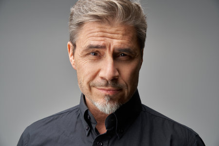 Business portrait - businessman smiling. Mature age, middle age, mid adult man in 50s with gray hair and happy confident smile. Copy space.の写真素材