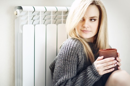 Young attractive girl sitting with a cup of coffeeの写真素材
