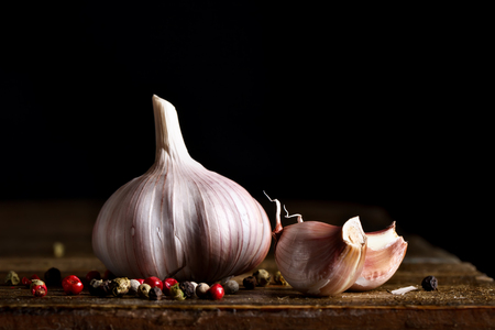 Still life of tomatoes, garlic and parsley on wooden boards. On a black background.の写真素材