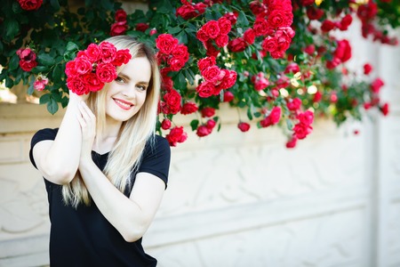 Beautiful young woman in a garden with roses.の写真素材