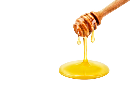 Fresh honey dripping from a spoon. On a white background.の写真素材