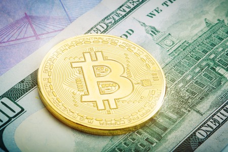 The gold coin of bitcoin lies on dollar and euro.の写真素材