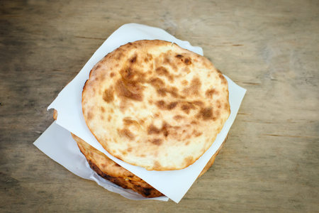 A stack of pita bread on a wooden table .