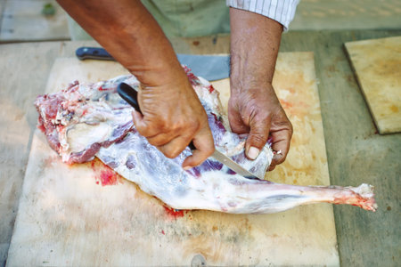 The man cuts meat of a ram for pilaf.