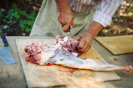 The man cuts meat of a ram for pilaf.の写真素材